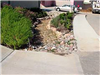 Rock lined drainage ditch with landscaping bushes