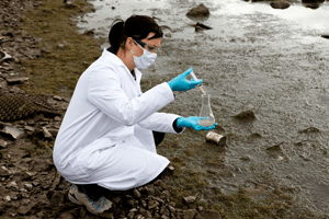 Woman getting water from the shoreline to test